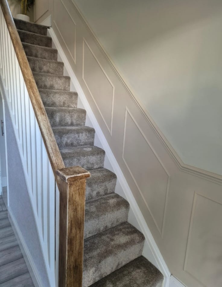 Elegant white shaker wall panelling along a custom stairway layout
